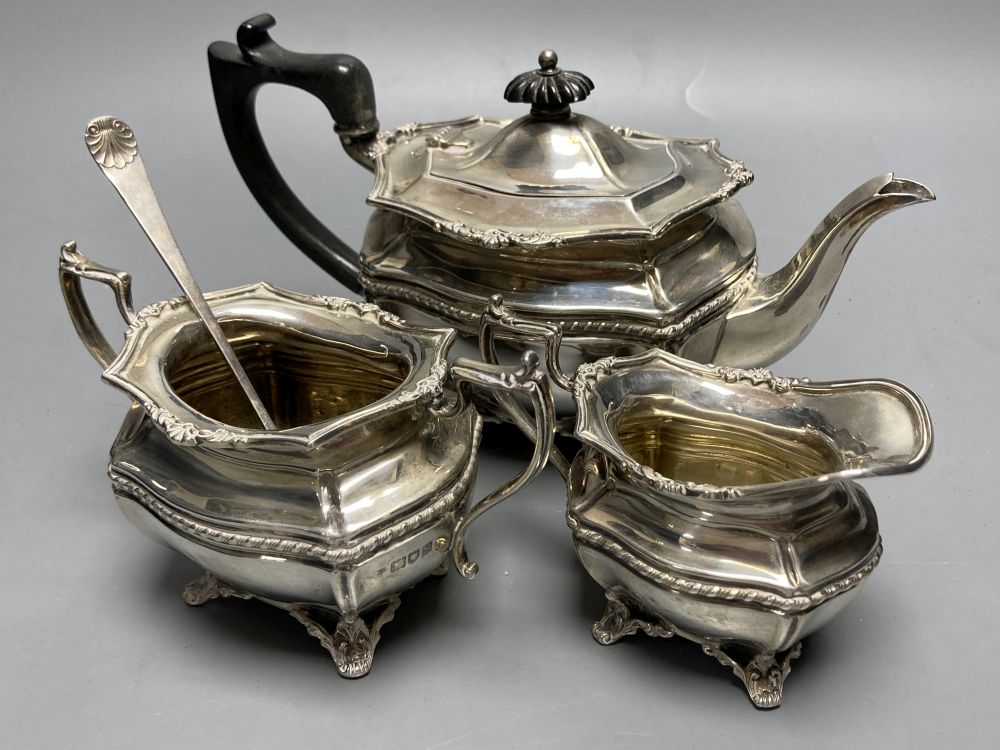 A George V silver bachelors three piece tea set, Josiah Williams & Co, London, 1913 and a silver pickle fork,